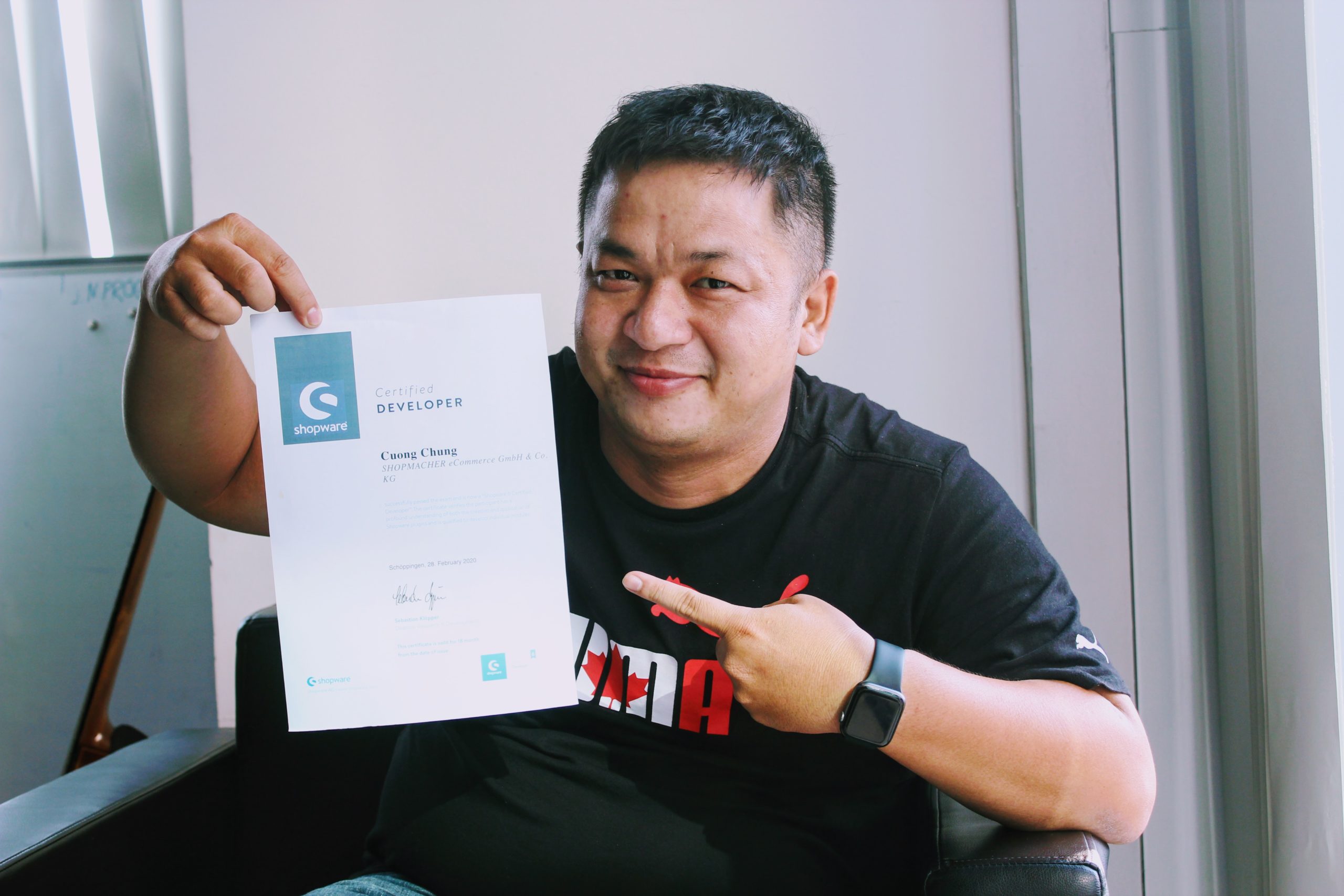 A Shopmacher employee from Vietnam shows his Shopware certification